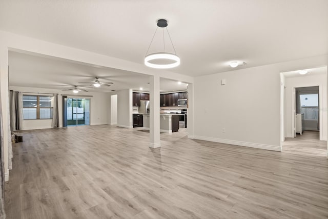 unfurnished living room featuring light hardwood / wood-style flooring and ceiling fan