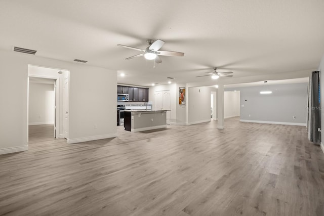 unfurnished living room with ceiling fan and hardwood / wood-style floors