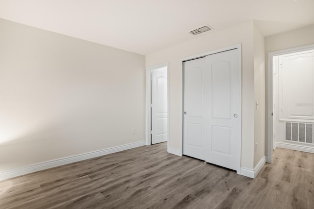 unfurnished bedroom featuring light hardwood / wood-style flooring and a closet