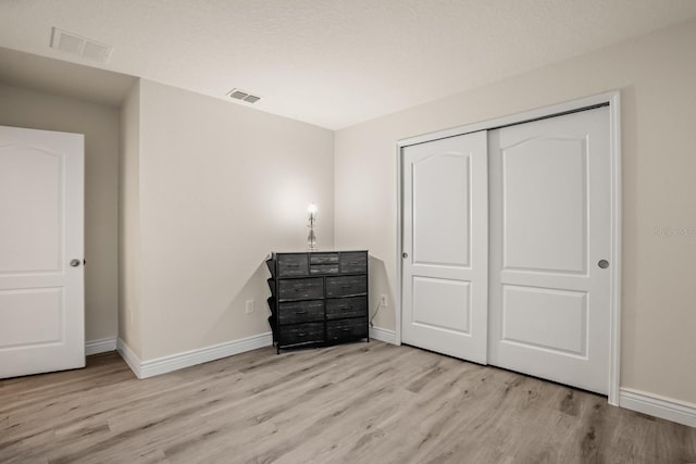 unfurnished bedroom featuring a closet and light wood-type flooring