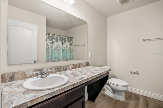 bathroom with vanity, toilet, and hardwood / wood-style floors