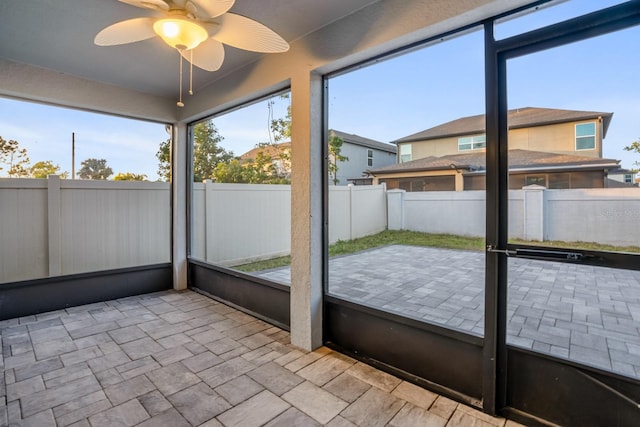 unfurnished sunroom featuring ceiling fan