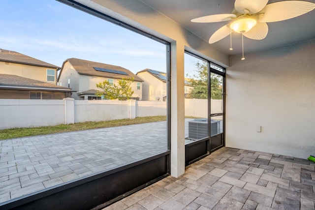 unfurnished sunroom featuring ceiling fan