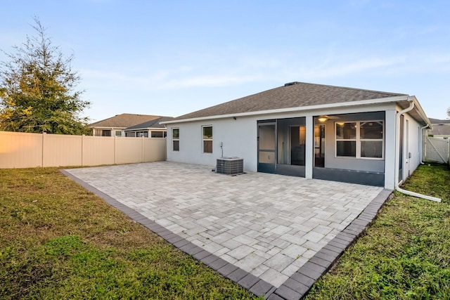 rear view of property featuring cooling unit, a yard, and a patio