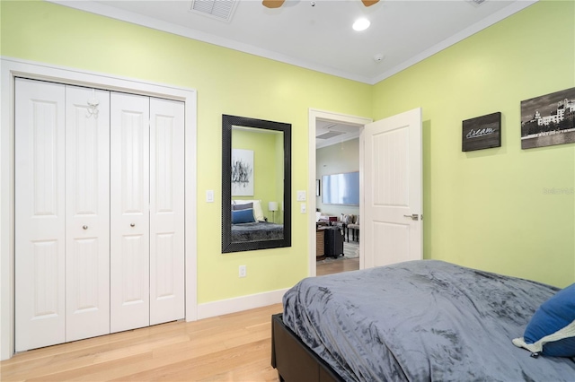 bedroom featuring hardwood / wood-style flooring, ornamental molding, a closet, and ceiling fan