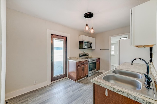 kitchen featuring sink, hanging light fixtures, a healthy amount of sunlight, and appliances with stainless steel finishes