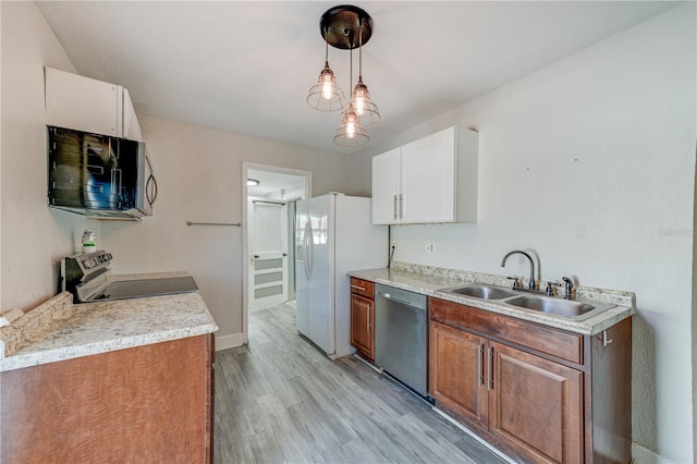 kitchen with sink, white cabinetry, decorative light fixtures, light hardwood / wood-style flooring, and stainless steel appliances