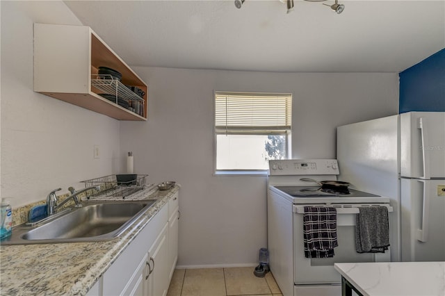 kitchen with sink, white appliances, light tile patterned floors, light stone countertops, and white cabinets