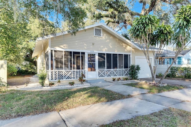 view of front of home featuring a garage and a sunroom