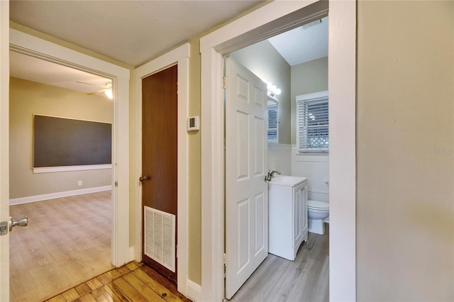 corridor with sink and light hardwood / wood-style floors