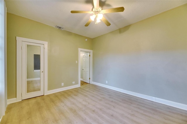 spare room with ceiling fan, a textured ceiling, and light wood-type flooring