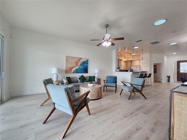 living room featuring ceiling fan and light wood-type flooring