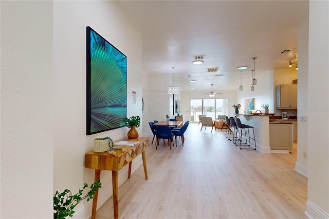 interior space with light wood-style floors, visible vents, and baseboards