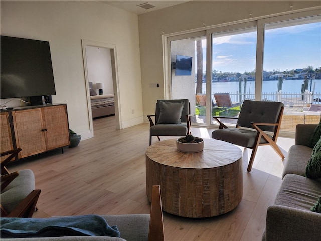 living area with baseboards, visible vents, and light wood finished floors