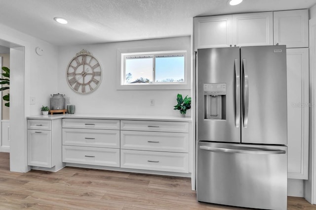 kitchen featuring white cabinetry, light wood-type flooring, and stainless steel refrigerator with ice dispenser