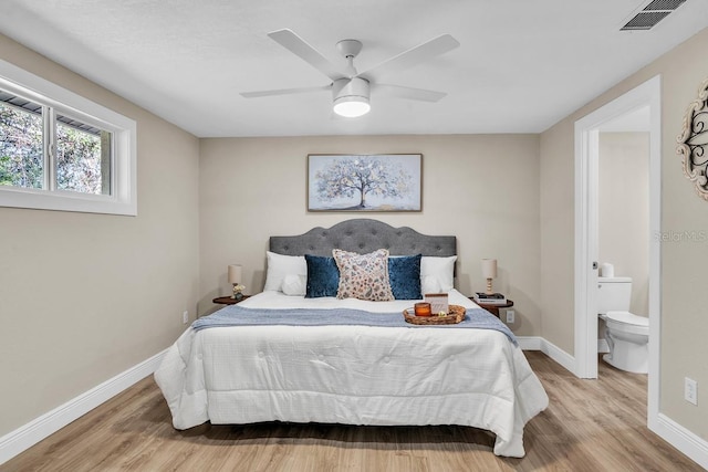 bedroom featuring hardwood / wood-style flooring, ceiling fan, and ensuite bath