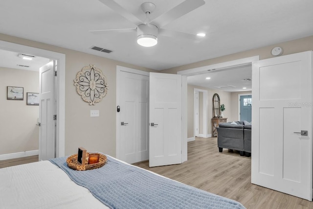 bedroom with ceiling fan, ensuite bathroom, and light hardwood / wood-style flooring