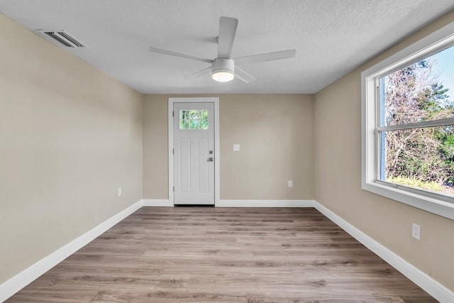 foyer with ceiling fan, a textured ceiling, and light hardwood / wood-style floors