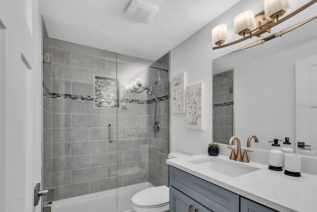 bathroom with vanity, a shower with shower door, a textured ceiling, and toilet