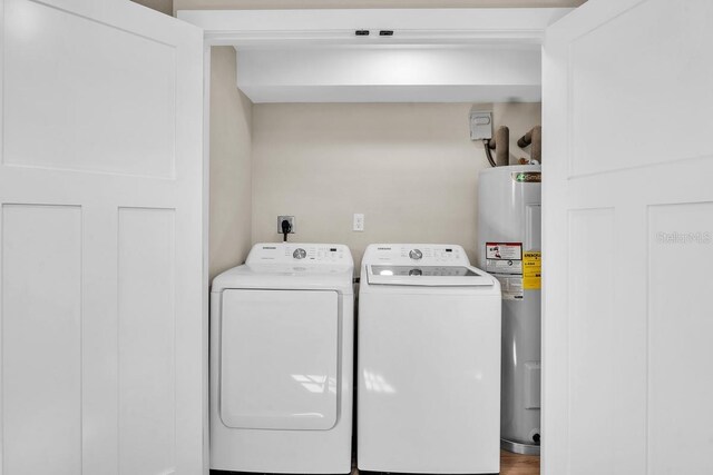 washroom with washer and clothes dryer and water heater