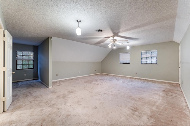 bonus room featuring light colored carpet, lofted ceiling, and a textured ceiling