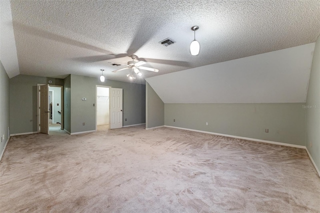 bonus room featuring lofted ceiling, ceiling fan, light carpet, and a textured ceiling