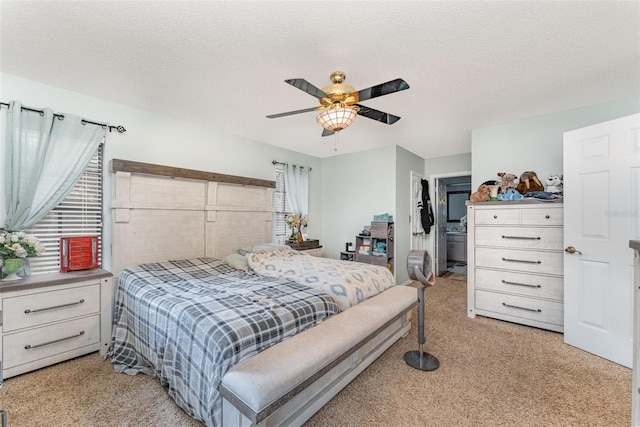 carpeted bedroom featuring ceiling fan and a textured ceiling