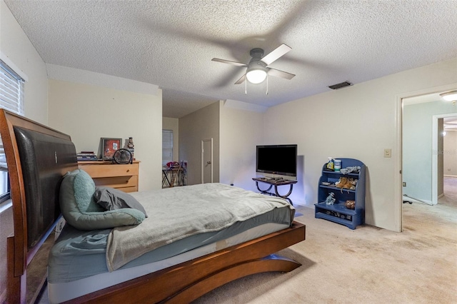 carpeted bedroom with a textured ceiling and ceiling fan