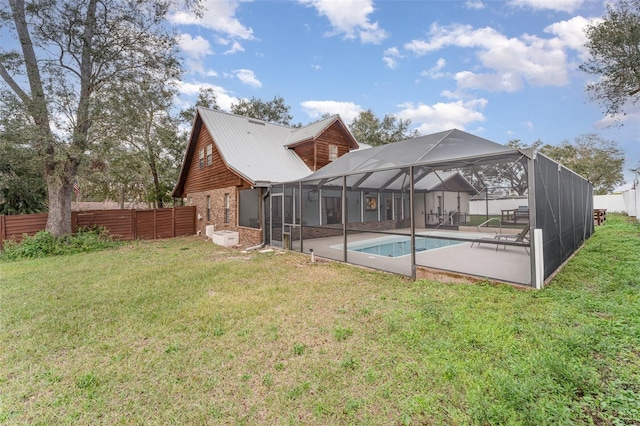 rear view of property with a fenced in pool, a patio area, glass enclosure, and a lawn