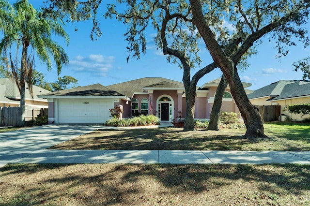 ranch-style home featuring a garage and a front lawn