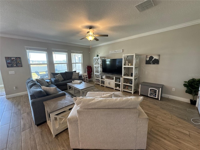 living room featuring hardwood / wood-style flooring, ornamental molding, a textured ceiling, and ceiling fan