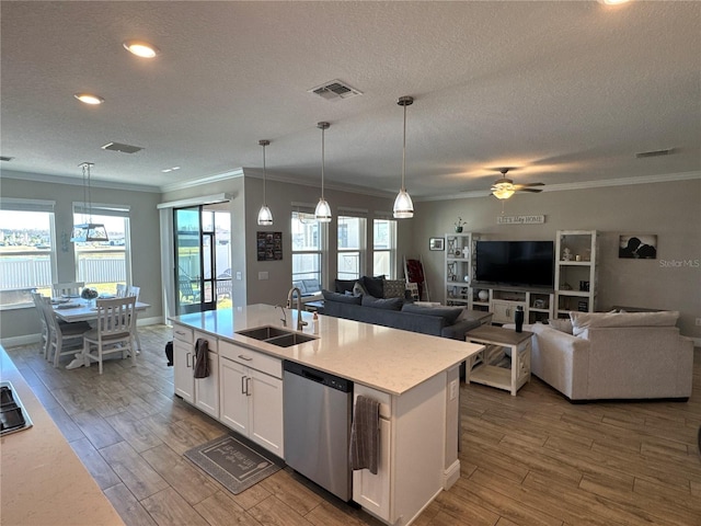 kitchen featuring decorative light fixtures, dishwasher, sink, white cabinets, and a kitchen island with sink