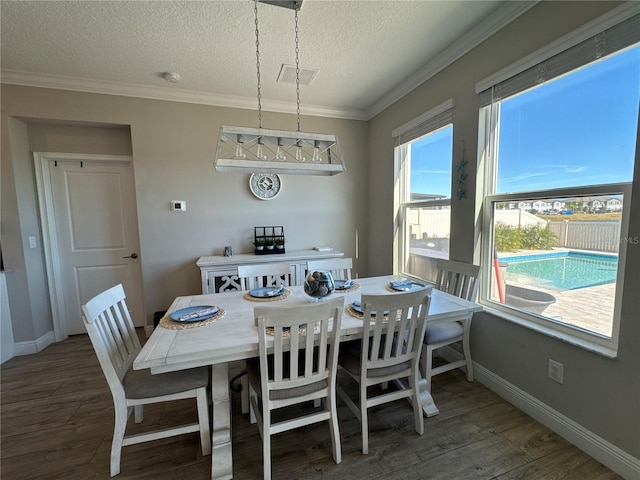 dining area featuring dark hardwood / wood-style flooring, crown molding, and a textured ceiling