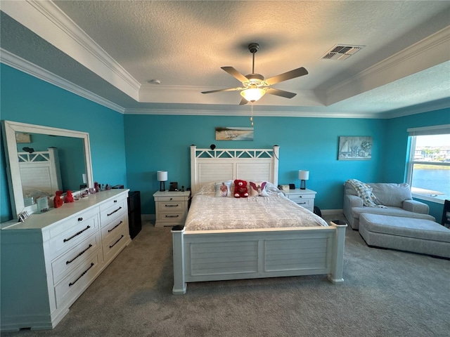 bedroom featuring a textured ceiling, a raised ceiling, ceiling fan, and carpet