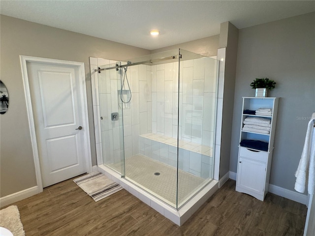 bathroom with an enclosed shower and hardwood / wood-style floors