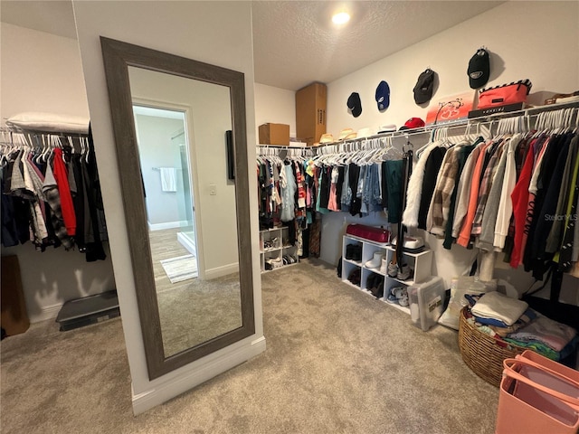 walk in closet with light colored carpet