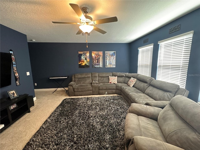 carpeted living room featuring ceiling fan and a textured ceiling