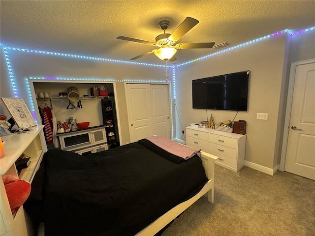 bedroom featuring light colored carpet, a textured ceiling, and ceiling fan