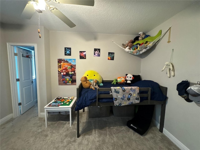 bedroom with ceiling fan, carpet flooring, and a textured ceiling