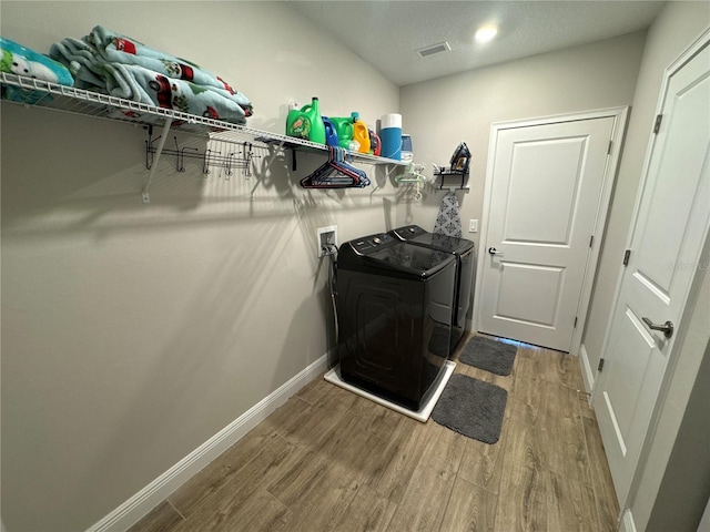 washroom featuring hardwood / wood-style flooring and washer and dryer