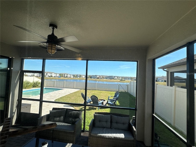 sunroom with a water view and ceiling fan