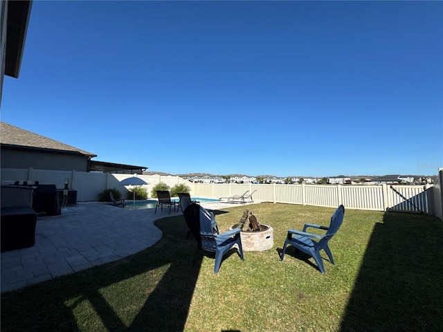 view of yard featuring a fenced in pool, a patio area, and a fire pit