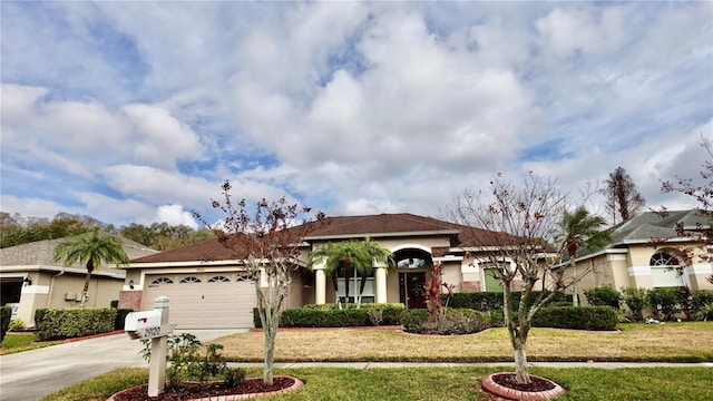 mediterranean / spanish home featuring a garage and a front lawn