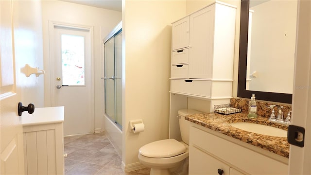 full bathroom with toilet, vanity, bath / shower combo with glass door, and tile patterned flooring