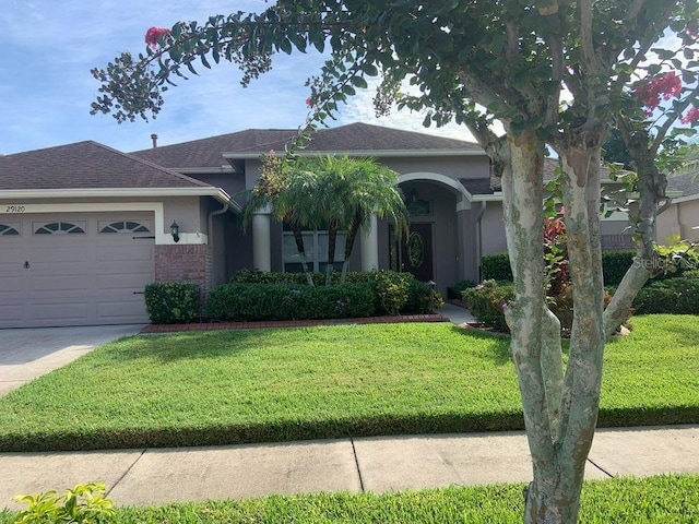 view of front of home with a garage and a front lawn