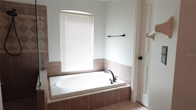 bathroom with tile patterned flooring and shower with separate bathtub