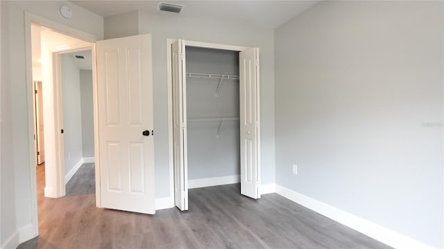 unfurnished bedroom with hardwood / wood-style floors and a closet