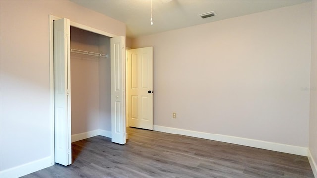 unfurnished bedroom with hardwood / wood-style flooring and a closet