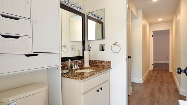 bathroom with vanity, hardwood / wood-style floors, and toilet