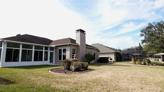 rear view of house with a sunroom and a lawn